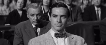 Movie still from “Compulsion” (1959), directed by Richard Fleischer – A black and white photo of a man in a suit and bow tie; Close Up shot, High angle