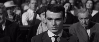 Movie still from “Compulsion” (1959), directed by Richard Fleischer – A man in a suit and tie in front of a group of people; Close Up shot, Low angle