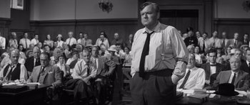 Movie still from “Compulsion” (1959), directed by Richard Fleischer – A man standing in front of a crowd of people in a courtroom; Medium shot, Low angle