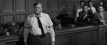 Movie still from “Compulsion” (1959), directed by Richard Fleischer – An older man standing in front of a table; Medium shot, Low angle
