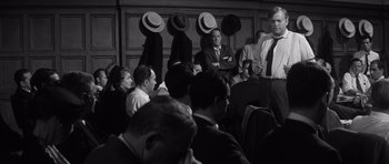 Movie still from “Compulsion” (1959), directed by Richard Fleischer – A black and white photo of a group of people in a room; Medium shot, Over the shoulder angle
