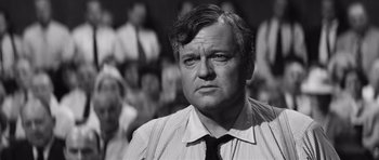 Movie still from “Compulsion” (1959), directed by Richard Fleischer – Black and white photograph of a man in front of a crowd; Close Up shot, Over the shoulder angle