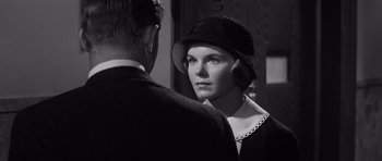 Movie still from “Compulsion” (1959), directed by Richard Fleischer – A woman wearing a hat standing next to a man; Close Up shot, Over the shoulder angle
