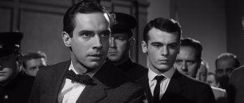 Movie still from “Compulsion” (1959), directed by Richard Fleischer – A man in a suit standing next to two other men; Close Up shot, Low angle