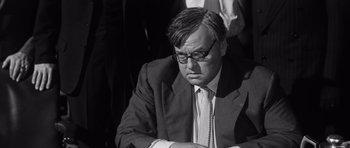 Movie still from “Compulsion” (1959), directed by Richard Fleischer – Black and white photograph of a man wearing a suit and tie; Close Up shot, High angle