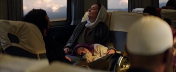 Movie still from “The Equalizer 2” (2018), directed by Antoine Fuqua – A woman and a child are sitting on a bus; Medium shot, High angle
