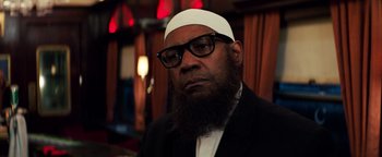 Movie still from “The Equalizer 2” (2018), directed by Antoine Fuqua – A man with a beard wearing glasses and a white hat; Close Up shot, Low angle