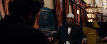 Movie still from “The Equalizer 2” (2018), directed by Antoine Fuqua – A man wearing a white hat and a black suit; Medium shot, Over the shoulder angle