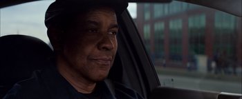 Movie still from “The Equalizer 2” (2018), directed by Antoine Fuqua – A man sitting in the passenger seat of a car; Close Up shot, Over the shoulder angle