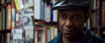 Movie still from “The Equalizer 2” (2018), directed by Antoine Fuqua – A person wearing a hat in a room; Close Up shot, Over the shoulder angle