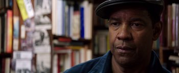 Movie still from “The Equalizer 2” (2018), directed by Antoine Fuqua – A person wearing a hat in a room; Close Up shot, Over the shoulder angle