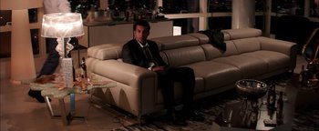 Movie still from “The Equalizer 2” (2018), directed by Antoine Fuqua – A man sitting on top of a couch in a living room; Wide shot, High angle