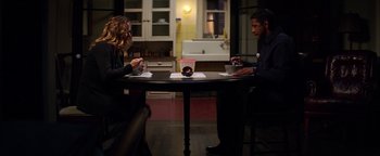 Movie still from “The Equalizer 2” (2018), directed by Antoine Fuqua – Two people sitting at a round table in a kitchen; Wide shot, High angle