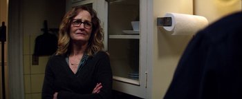 Movie still from “The Equalizer 2” (2018), directed by Antoine Fuqua – A woman standing in front of a cabinet with dishes on it; Close Up shot, Over the shoulder angle