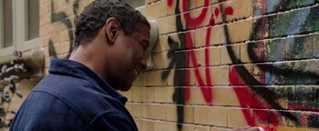 Movie still from “The Equalizer 2” (2018), directed by Antoine Fuqua – A man standing in front of a brick wall; Close Up shot, Over the shoulder angle