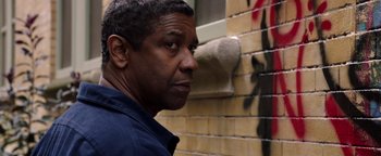 Movie still from “The Equalizer 2” (2018), directed by Antoine Fuqua – A man standing in front of a brick wall looking to his left; Close Up shot, Low angle