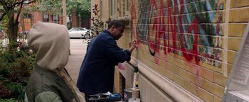 Movie still from “The Equalizer 2” (2018), directed by Antoine Fuqua – A man painting a wall with a spray paint gun; Medium shot, Low angle