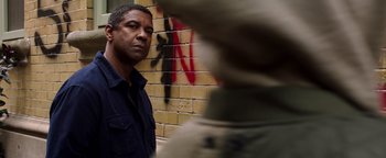 Movie still from “The Equalizer 2” (2018), directed by Antoine Fuqua – A man standing in front of a brick wall; Medium shot, Over the shoulder angle