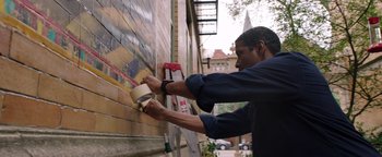 Movie still from “The Equalizer 2” (2018), directed by Antoine Fuqua – A man painting a brick wall on the side of a building; Medium shot, Low angle
