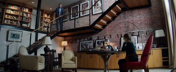 Movie still from “The Equalizer 2” (2018), directed by Antoine Fuqua – A man standing in a living room next to a table; Wide shot, Low angle