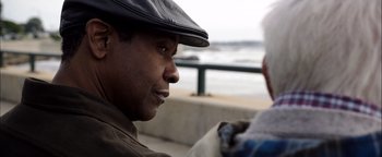 Movie still from “The Equalizer 2” (2018), directed by Antoine Fuqua – A person wearing a hat near a body of water; Close Up shot, Over the shoulder angle