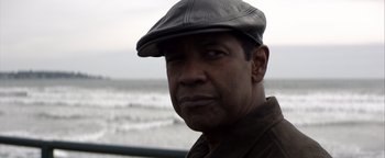 Movie still from “The Equalizer 2” (2018), directed by Antoine Fuqua – A person wearing a hat near a body of water; Close Up shot, Low angle