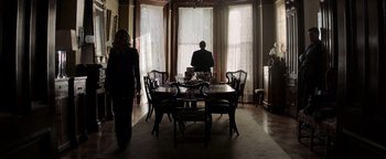 Movie still from “The Equalizer 2” (2018), directed by Antoine Fuqua – A man sitting at a dining room table in front of a woman; Wide shot, Low angle