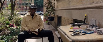 Movie still from “The Equalizer 2” (2018), directed by Antoine Fuqua – A man sitting on top of a bench reading a book; Medium shot, Over the shoulder angle