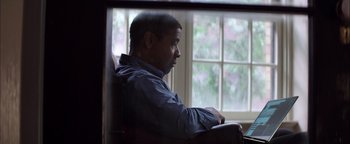 Movie still from “The Equalizer 2” (2018), directed by Antoine Fuqua – A man sitting in a chair looking out a window; Medium shot, Over the shoulder angle