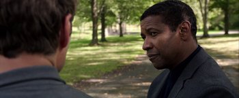 Movie still from “The Equalizer 2” (2018), directed by Antoine Fuqua – Two men standing next to each other in a park; Close Up shot, Over the shoulder angle