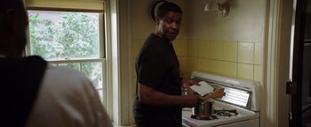 Movie still from “The Equalizer 2” (2018), directed by Antoine Fuqua – A man standing in a kitchen preparing a meal; Medium shot, Over the shoulder angle