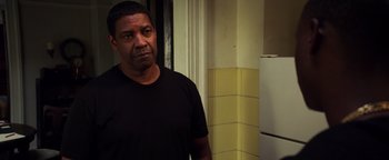 Movie still from “The Equalizer 2” (2018), directed by Antoine Fuqua – A man standing in front of a refrigerator in a kitchen; Close Up shot, Over the shoulder angle