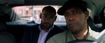 Movie still from “The Equalizer 2” (2018), directed by Antoine Fuqua – Two men sitting in the back seat of a car; Close Up shot, Over the shoulder angle