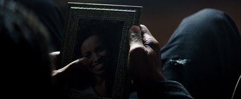 Movie still from “The Equalizer 2” (2018), directed by Antoine Fuqua – A person holding a picture of a smiling woman; Extreme Close Up shot, Over the shoulder angle