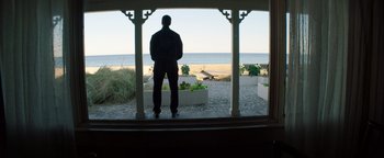 Movie still from “The Equalizer 2” (2018), directed by Antoine Fuqua – A man standing on a porch looking out at the ocean; Wide shot, Low angle