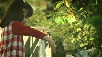 Movie still from “Confessions” (2010), directed by Tetsuya Nakashima – A little girl pointing to a tree in a yard; Medium shot, High angle