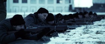 Movie still from “Confessions of a Dangerous Mind” (2002), directed by George Clooney – Two men are laying in the snow with rifles in their hands; Medium shot, Low angle