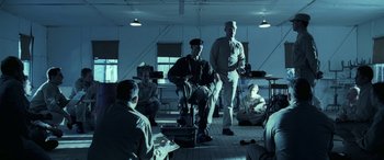 Movie still from “Confessions of a Dangerous Mind” (2002), directed by George Clooney – A group of people sitting in a room; Wide shot, High angle