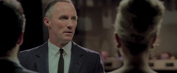 Movie still from “Confessions of a Dangerous Mind” (2002), directed by George Clooney – A person wearing a suit and a tie; Close Up shot, Over the shoulder angle