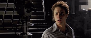 Movie still from “Confessions of a Dangerous Mind” (2002), directed by George Clooney – A man in striped shirt standing in front of stairs; Close Up shot, Low angle