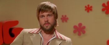 Movie still from “Confessions of a Dangerous Mind” (2002), directed by George Clooney – A man with a long hair and a beard wearing a jacket; Close Up shot, Over the shoulder angle