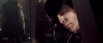 Movie still from “Confessions of a Dangerous Mind” (2002), directed by George Clooney – A person wearing a hat and a tie; Close Up shot, Low angle