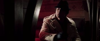 Movie still from “Confessions of a Dangerous Mind” (2002), directed by George Clooney – A man wearing a hat and a coat; Close Up shot, Low angle