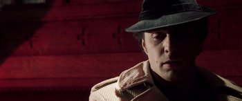 Movie still from “Confessions of a Dangerous Mind” (2002), directed by George Clooney – A man wearing a hat and a jacket; Close Up shot, Low angle