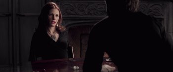 Movie still from “Confessions of a Dangerous Mind” (2002), directed by George Clooney – A woman sitting at a wooden table in front of a mirror; Medium shot, Over the shoulder angle