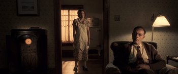 Movie still from “Confessions of a Dangerous Mind” (2002), directed by George Clooney – A woman standing in a room in front of an open door; Wide shot, Low angle