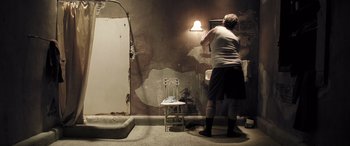Movie still from “Confessions of a Dangerous Mind” (2002), directed by George Clooney – A woman standing in front of a sink in a room; Wide shot, Low angle