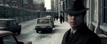 Movie still from “Confessions of a Dangerous Mind” (2002), directed by George Clooney – A man wearing a hat standing in the street; Close Up shot, Low angle