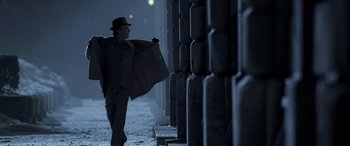 Movie still from “Confessions of a Dangerous Mind” (2002), directed by George Clooney – A man walking down a street holding a bag; Wide shot, Low angle