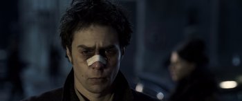 Movie still from “Confessions of a Dangerous Mind” (2002), directed by George Clooney – A man with a bandage on his face; Close Up shot, Low angle